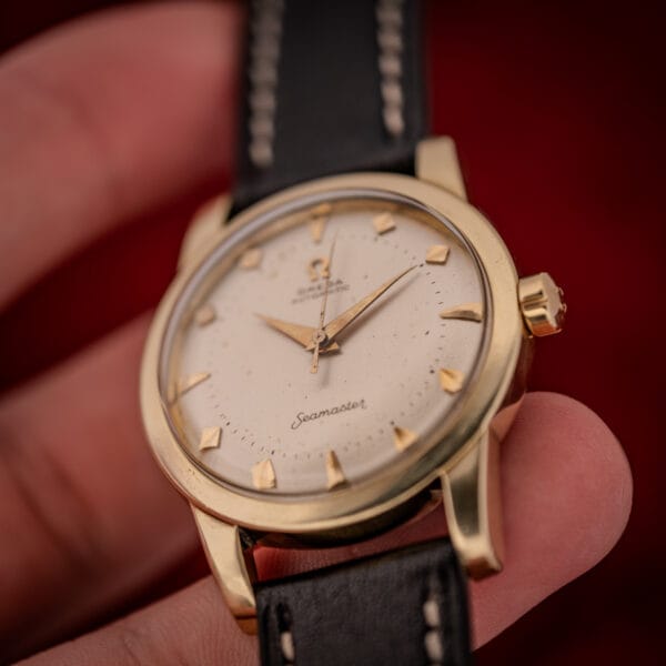 Omega Seamaster cream dial in hand showing honest age speckle and warm marker patina under a domed crystal
