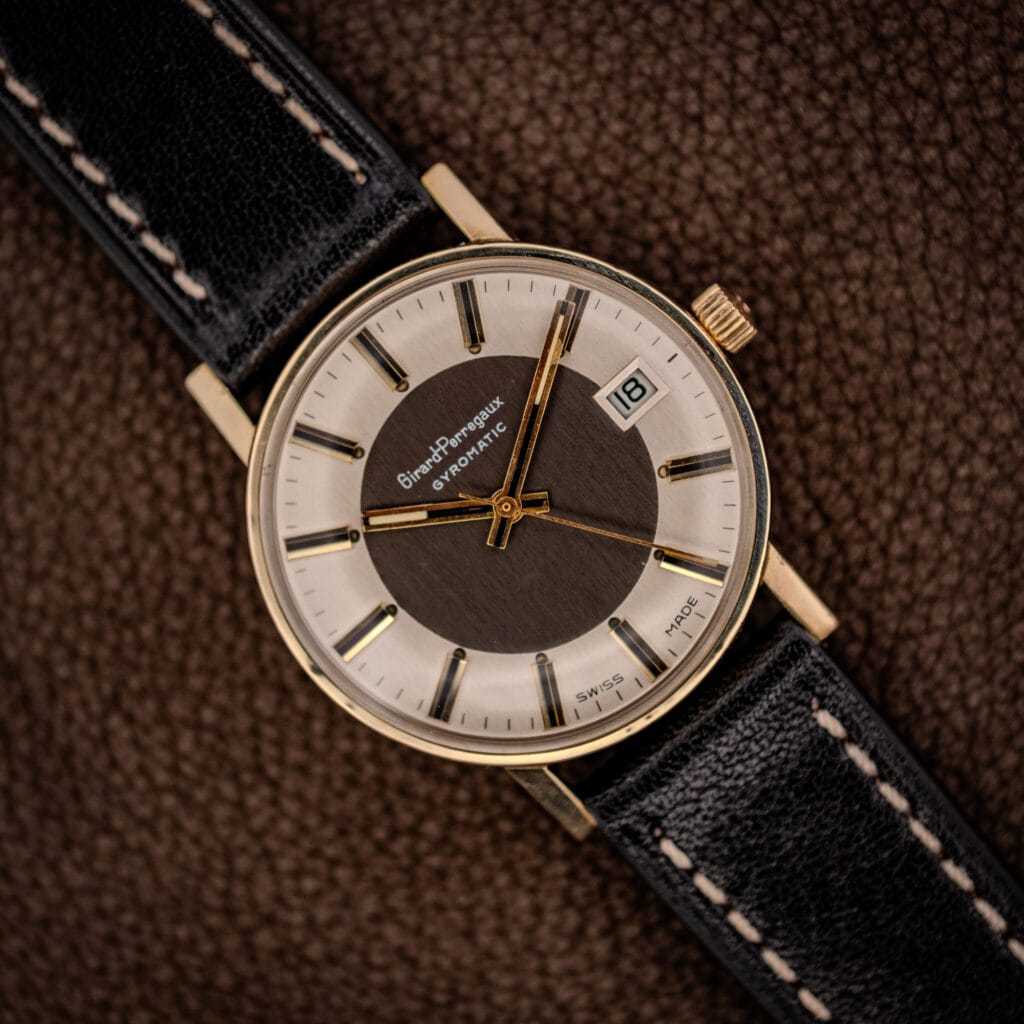 Girard-Perregaux Gyromatic two-tone tuxedo dial, silver chapter ring around a dark center, gold baton markers and date at three