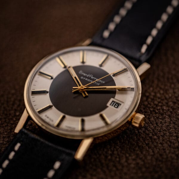 Girard-Perregaux Gyromatic gold-filled case at an angle, domed acrylic crystal over the two-tone tuxedo dial