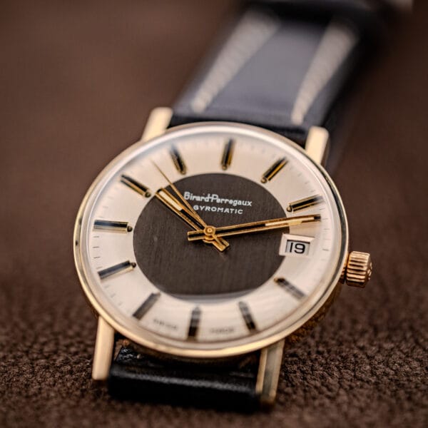 Girard-Perregaux Gyromatic showing gold dauphine hands, center seconds and the fluted signed crown at three