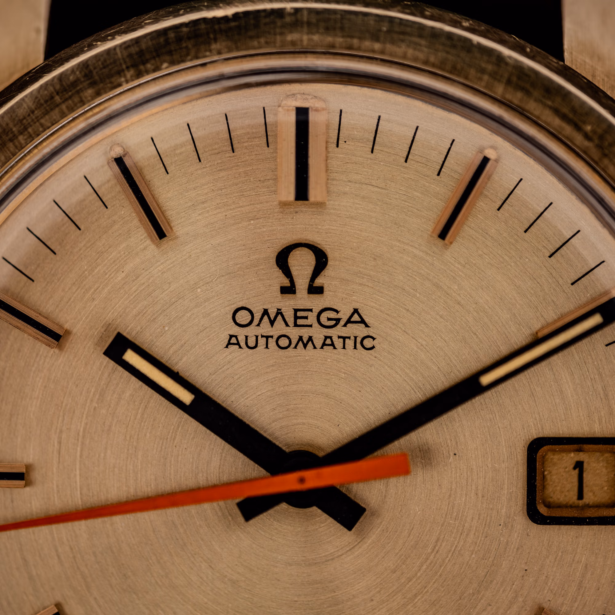 Omega Seamaster 166.028 dial close-up showing applied Omega symbol, OMEGA AUTOMATIC text and faceted baton markers