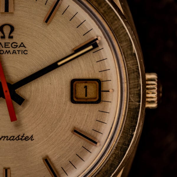Omega Seamaster 166.028 aged date wheel at three o'clock beside the signed gold Omega crown