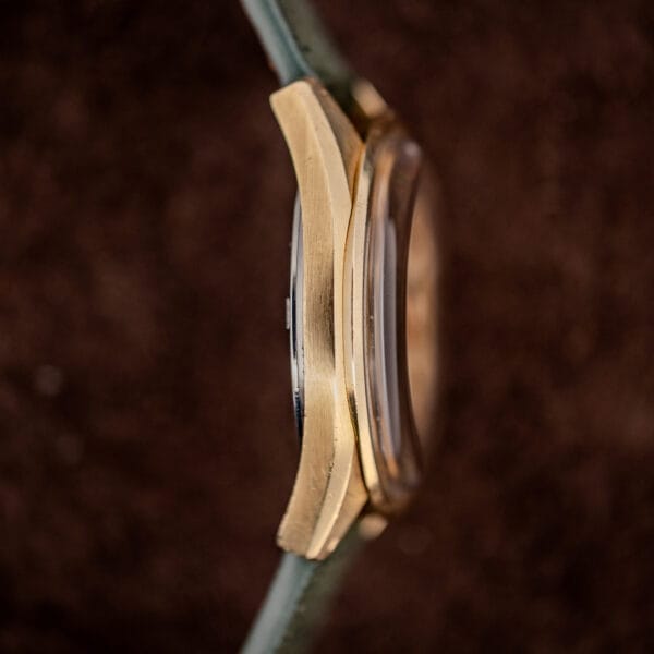 Omega Seamaster 166.028 side view showing domed acrylic crystal and gold cap over stainless steel case