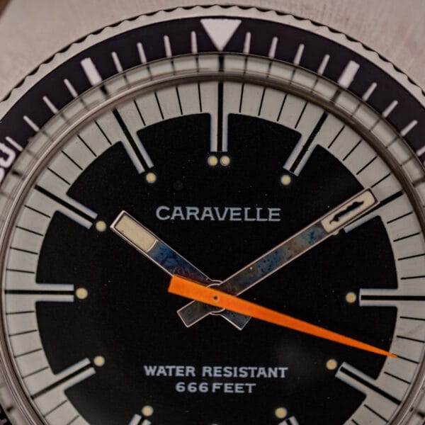 Caravelle Devil Diver dial close-up with WATER RESISTANT 666 FEET printing and orange central seconds hand