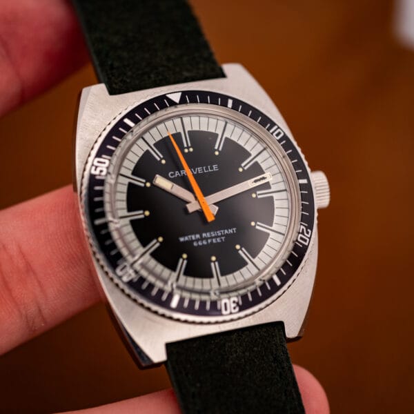 Caravelle Devil Diver ref 3286-DP held in hand showing black dial and orange seconds sweep