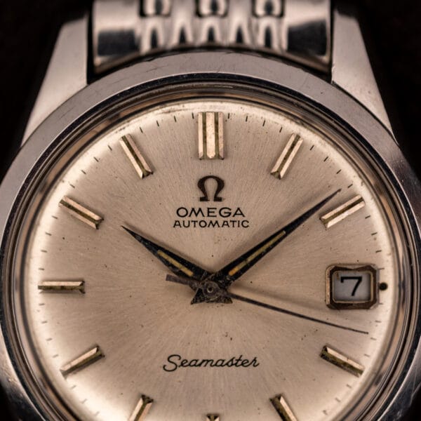 Omega Seamaster 166.010 silver dial close-up showing applied baton markers and date window at three