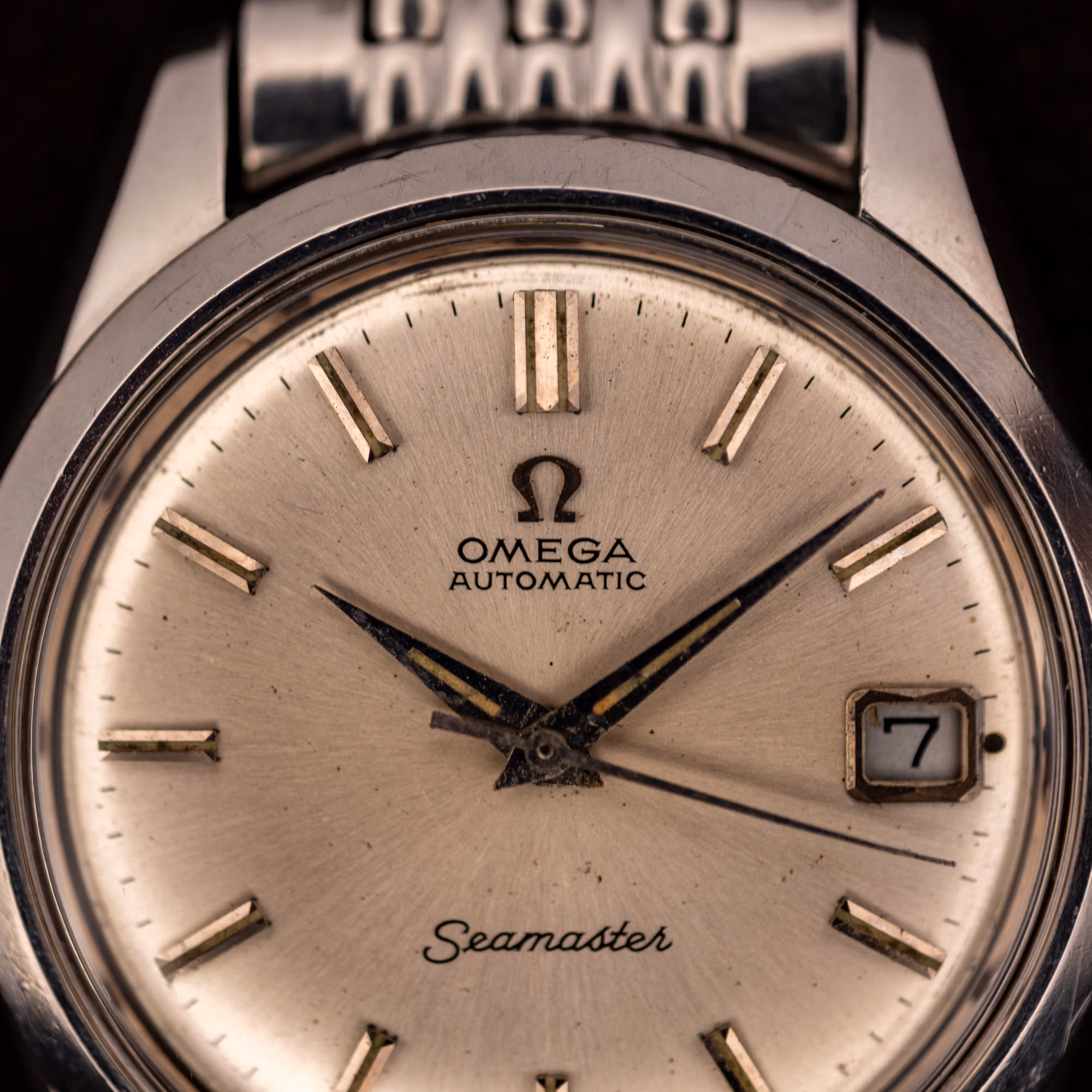 Omega Seamaster 166.010 silver dial close-up showing applied baton markers and date window at three
