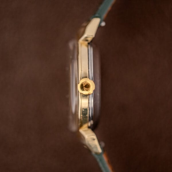 Omega hooded lugs 14363 side profile showing gold-capped bezel over stainless steel back and signed crown