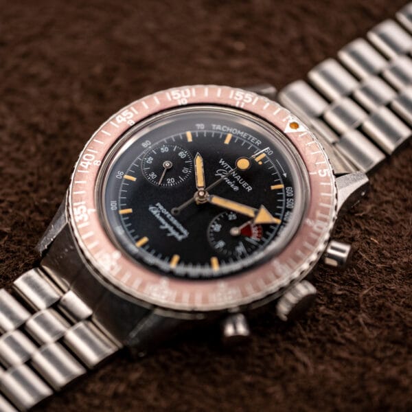 Angled view of the Wittnauer 7004A Professional Chronograph and its faded burgundy elapsed-time bezel on a beads-of-rice bracelet
