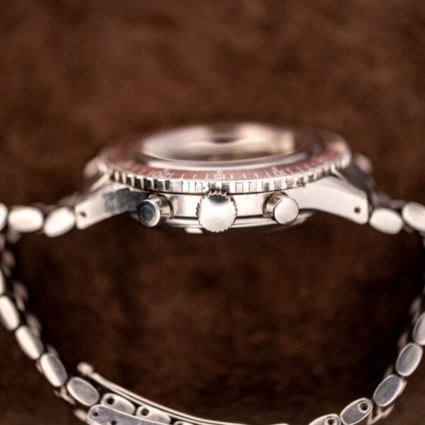 Side profile of the Wittnauer 7004A showing dual pump pushers, signed crown and coin-edge rotating bezel