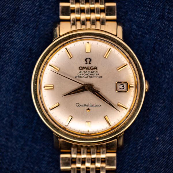 Omega Constellation 168.004 silver sunburst dial with date at three, dauphine hands, and gold-capped bezel