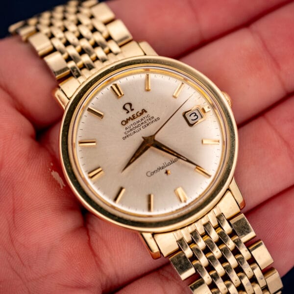 Vintage Omega Constellation 168.004 held in hand, silver chronometer dial and gold-filled beads-of-rice bracelet
