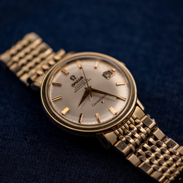 Omega Constellation 168.004 gold-capped case on 14k gold-filled bracelet photographed against a deep blue background