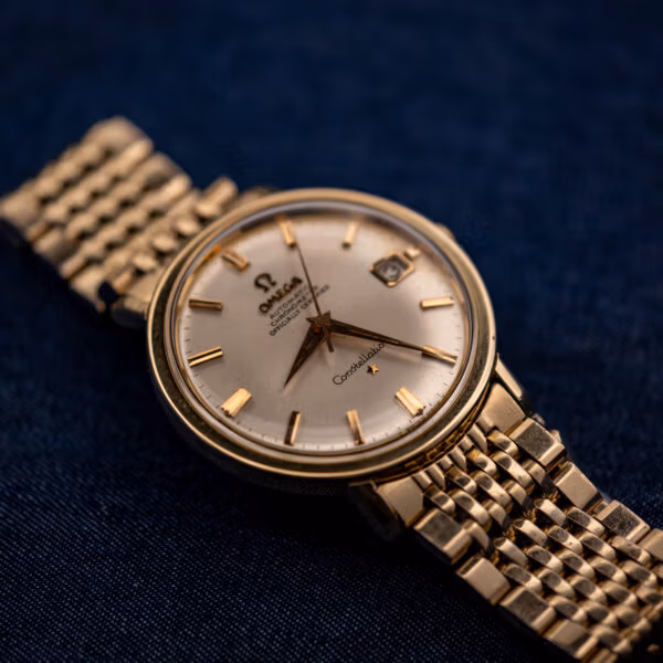 Omega Constellation 168.004 gold-capped case on 14k gold-filled bracelet photographed against a deep blue background