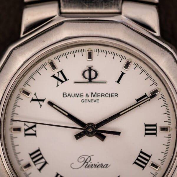 Baume & Mercier Riviera dial close-up showing Phi logo, GENEVE signature, applied baton markers and black Roman numerals