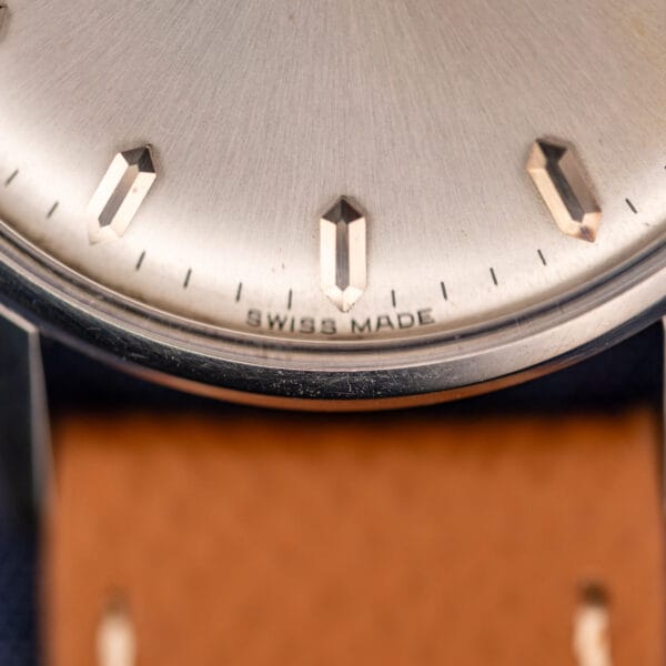 Omega caliber 285 dial lower half with SWISS MADE printed above six and faceted pink-gold baton markers