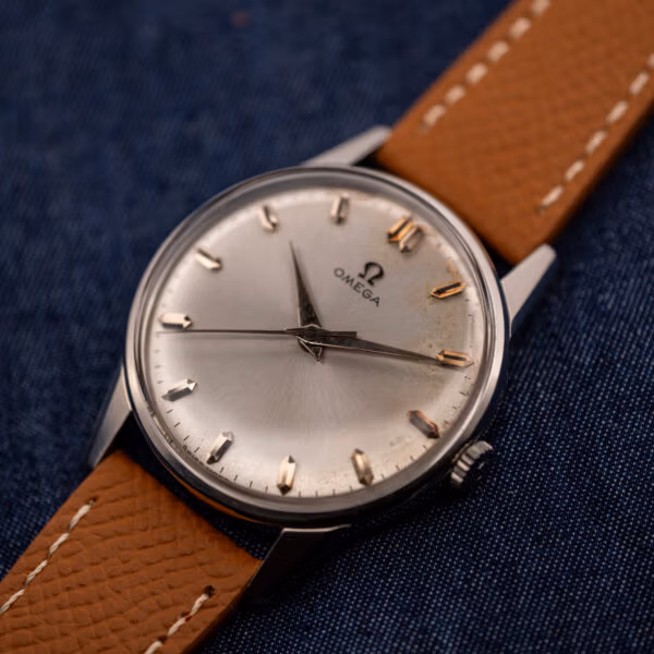 Omega 14772 SC stainless steel dress watch at an angle showing the silver sunburst dial and signed crown