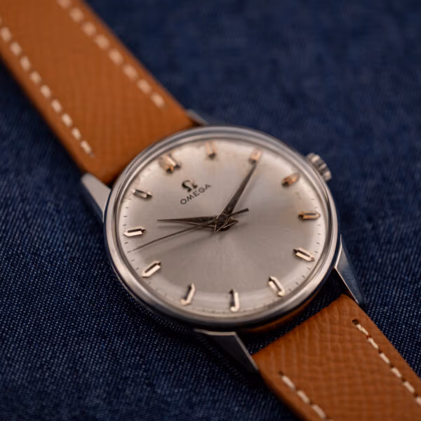 Omega 14772 silver sunburst dial straight on with center seconds hand and the Omega-signed crown at three