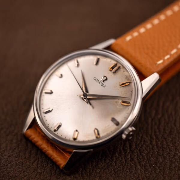 Omega 14772 SC silver sunburst dial on brown leather showing honest age toning beside the markers