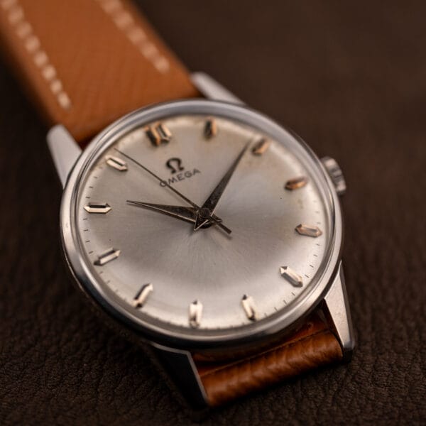 Omega 14772 dress watch angled with pink-gold faceted markers catching light across the sunburst dial