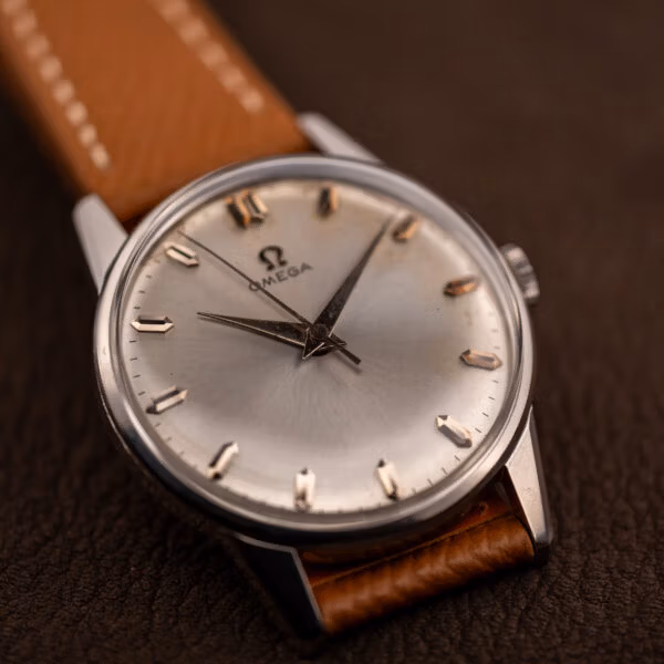 Omega 14772 dress watch angled with pink-gold faceted markers catching light across the sunburst dial