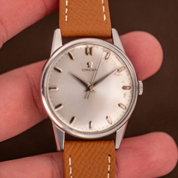 Omega 14772 SC 34.5mm steel case held in hand showing the dial proportions and tan calf strap