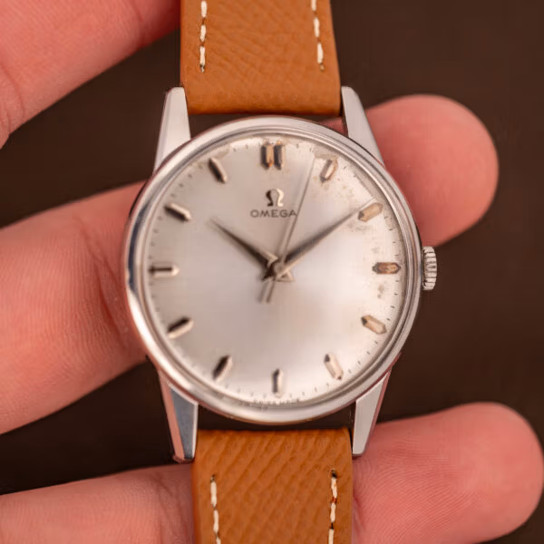 Omega 14772 SC 34.5mm steel case held in hand showing the dial proportions and tan calf strap