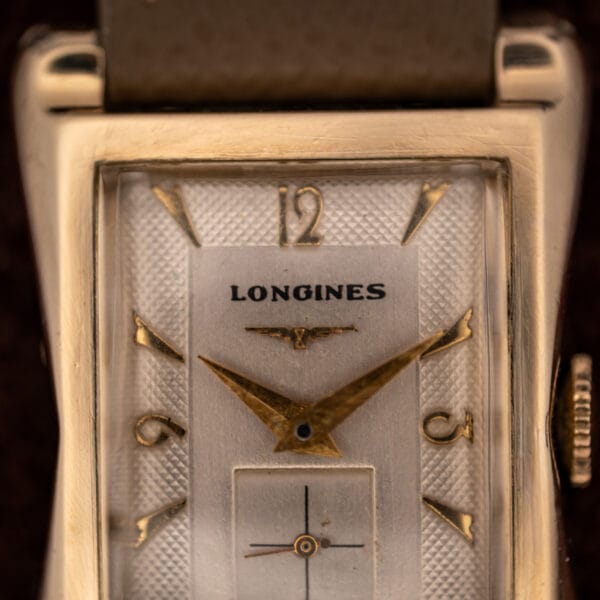 Longines 2148-1 dial close-up showing the winged hourglass logo, applied gold numerals and faceted dauphine hands