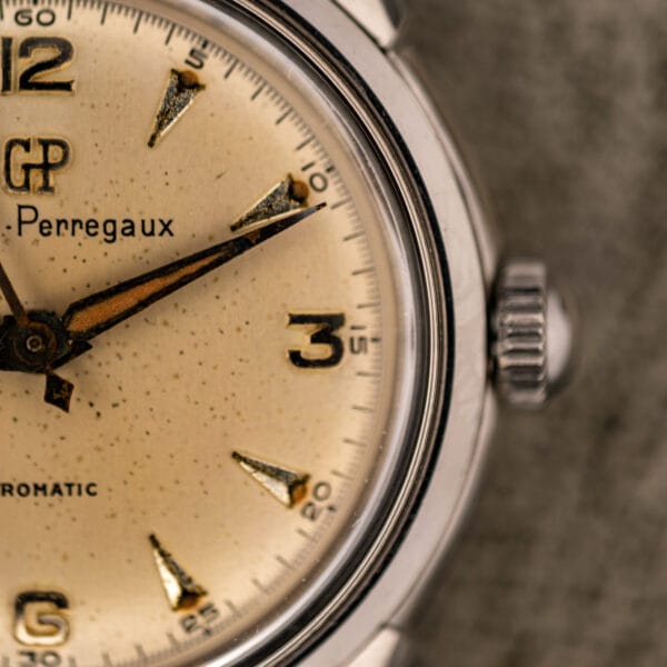 Girard-Perregaux Gyromatic 6170 dial close-up with speckled cream patina and fluted steel crown at three