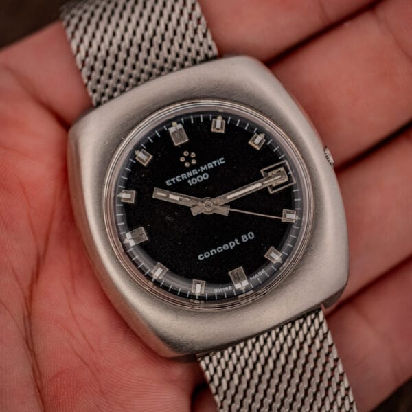 Eterna Matic 1000 Concept 80 ref 156T held in hand showing black dial and steel mesh bracelet