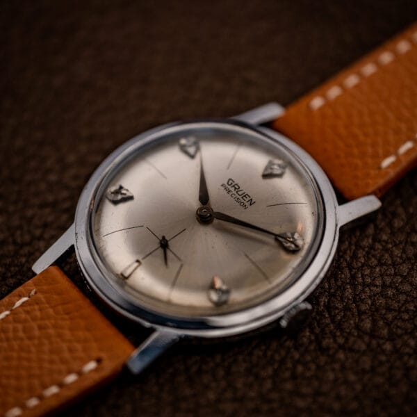Gruen Precision N510R watch three-quarter view showing sunburst dial, diamond markers and signed crown