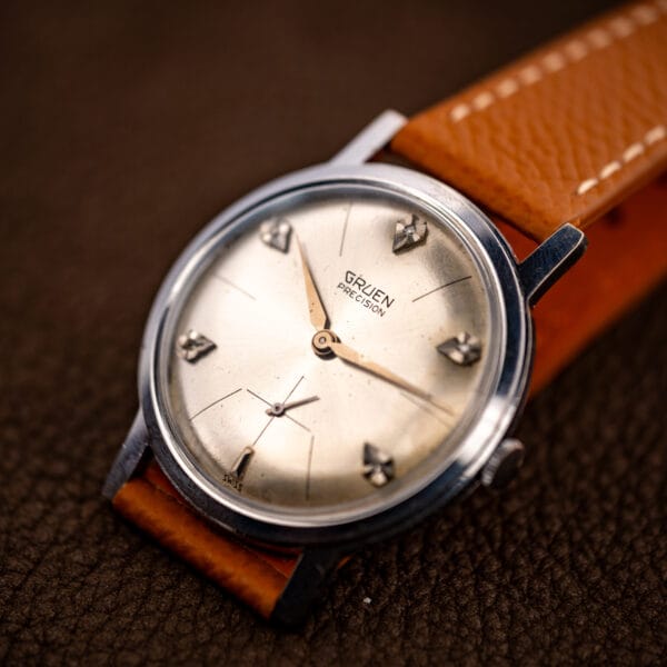 Vintage Gruen Precision diamond sunburst dial watch on honey leather, three-quarter dial view