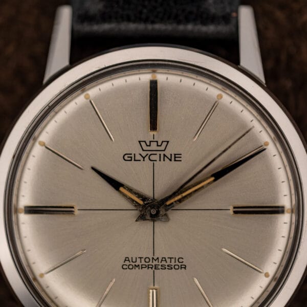 Glycine ref. 645 silver sunburst dial overhead with aged lume pips and faceted dauphine hands