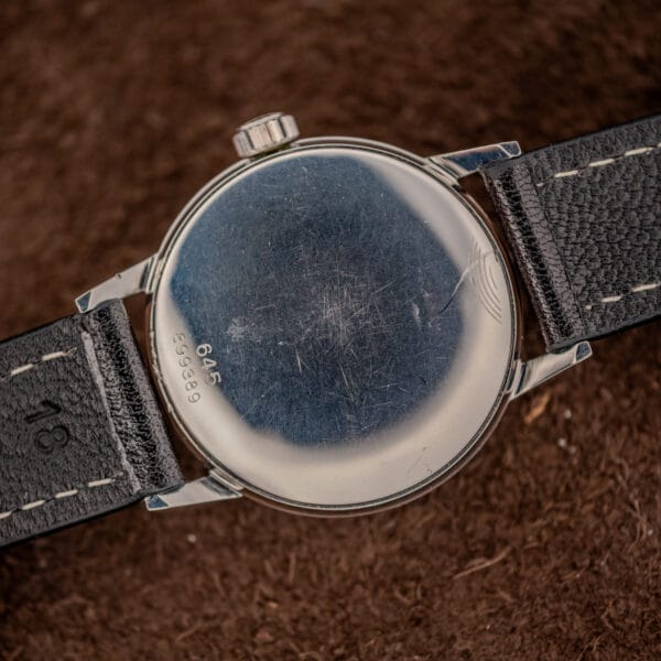 Glycine 645 snap-on steel caseback with light hairlines, stamped 645 over serial 899389