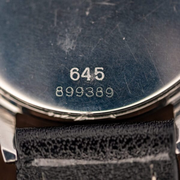 Glycine Compressor caseback stamping in macro reading 645 over 899389 on brushed steel