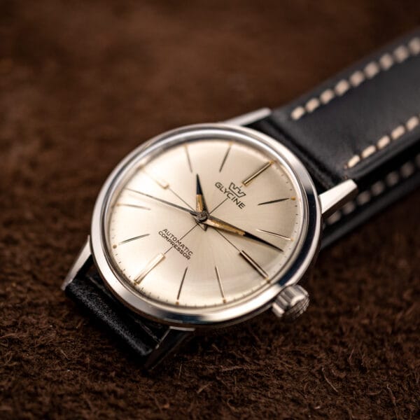 Vintage Glycine automatic Compressor 645 silver dial and polished case from a low side angle