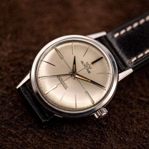 Glycine Compressor 645 silver sunburst dial and warmly aged dauphine hands in a three-quarter beauty shot