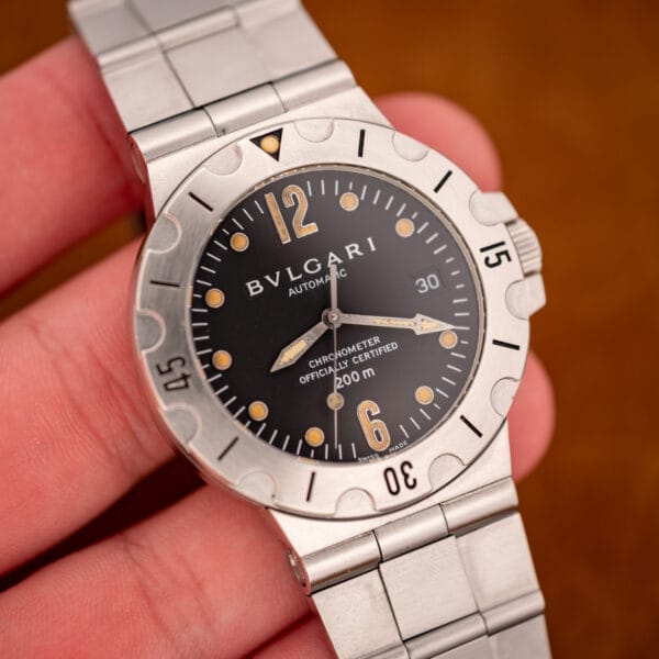 Bulgari Diagono Scuba SD38S held in hand showing black chronometer dial and lume pip at twelve