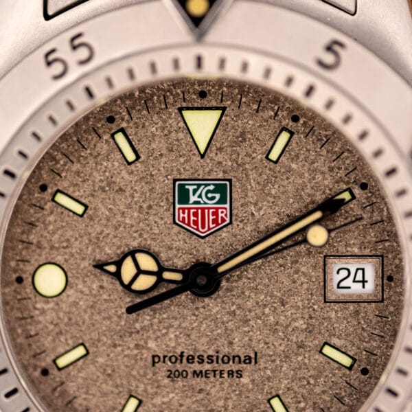 TAG Heuer 1500 Series granite speckled dial close-up with red and green shield logo and professional 200 meters text