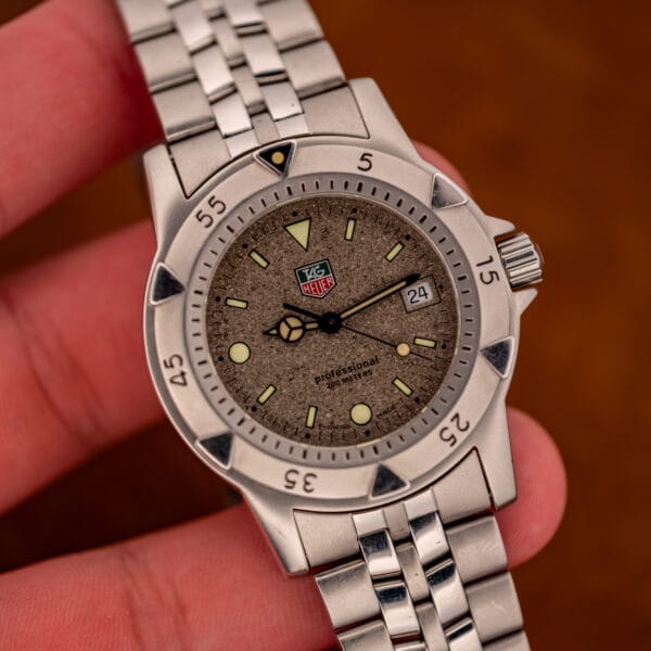 Vintage TAG Heuer 1500 Series granite dial diver held in hand showing tritium markers and date