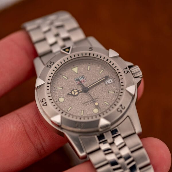 TAG Heuer 1500 Series WD1211-K-20 in hand, granite stone dial and luminous baton hands at an angle