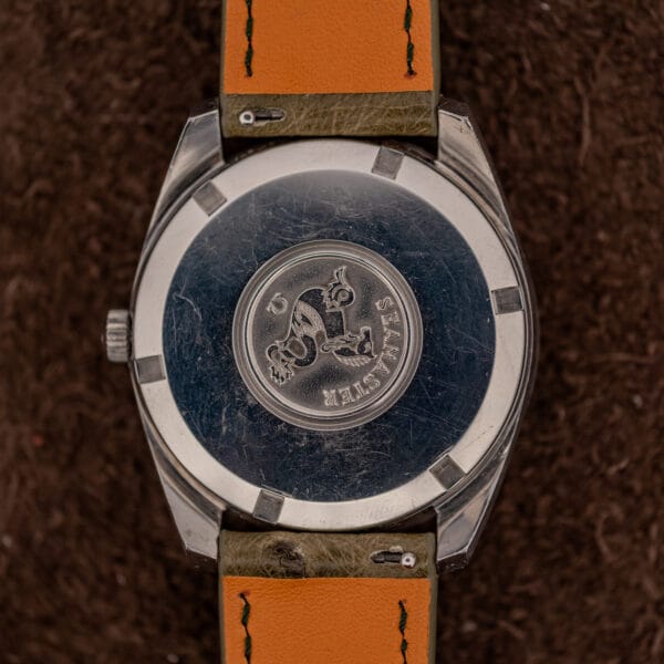 Omega Seamaster outer caseback with raised hippocampus seahorse medallion on olive Ostrich leather strap
