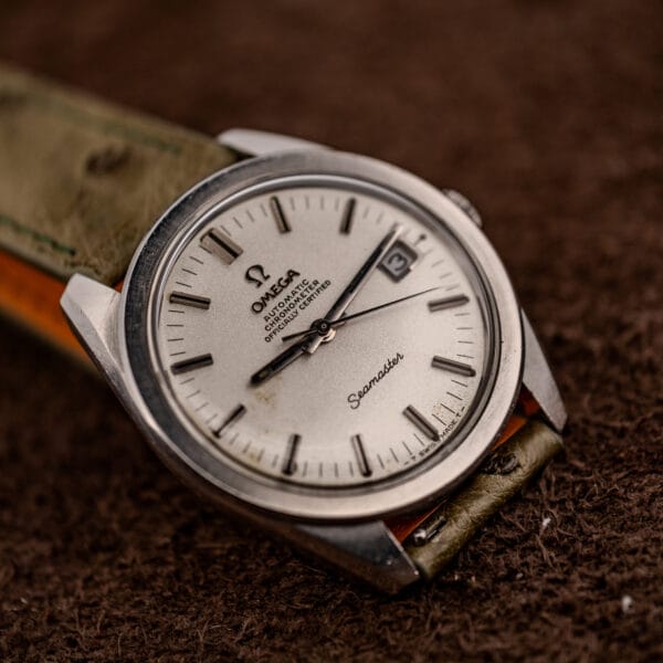 Omega Seamaster Chronometer three-quarter view on soft brown ground showing sandblasted dial and faceted batons