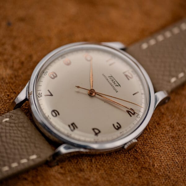 Tissot Antimagnetique 66718 angled view on grey-taupe textured leather strap with cream contrast stitching