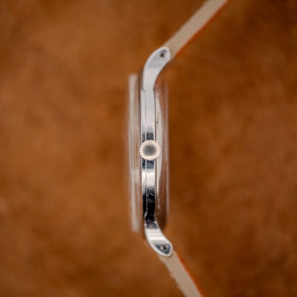 Tissot 66718 case side profile showing slim polished steel band, signed crown and domed acrylic crystal