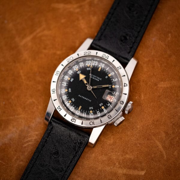 Vintage Glycine Airman automatic on black ostrich strap, three-quarter angled view on tan leather