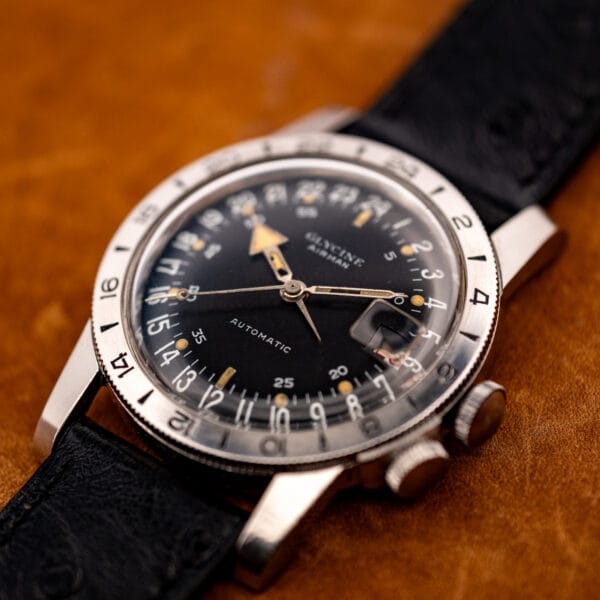 Glycine Airman GMT twin-crown steel case and coin-edge 24-hour bezel, dramatic angled studio shot