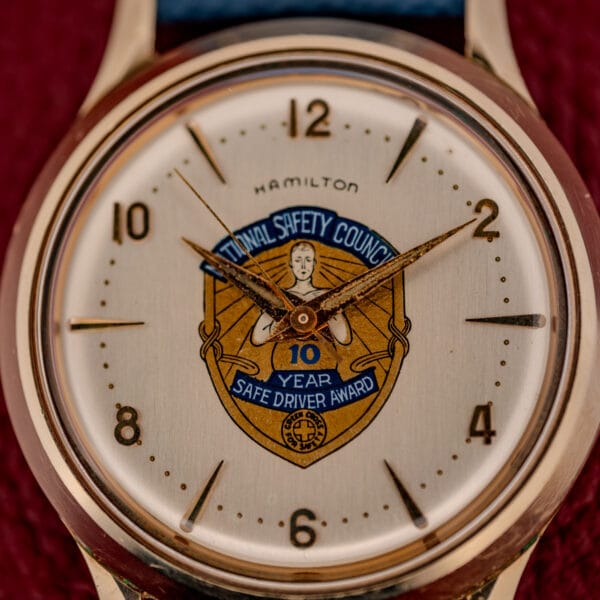 Hamilton Thin-O-Matic dial detail with applied gold numerals, dauphine hands and the Safe Driver Award presentation crest