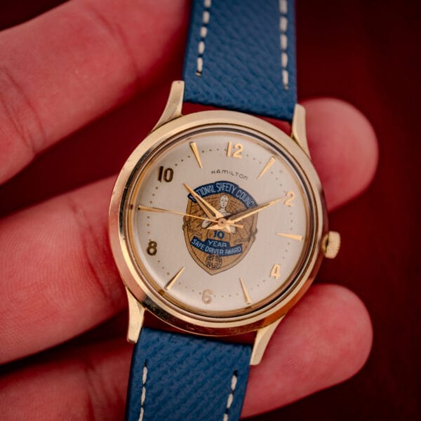 Hamilton Thin-O-Matic Safe Driver Award watch held in hand showing the cream dial and 10k gold filled case