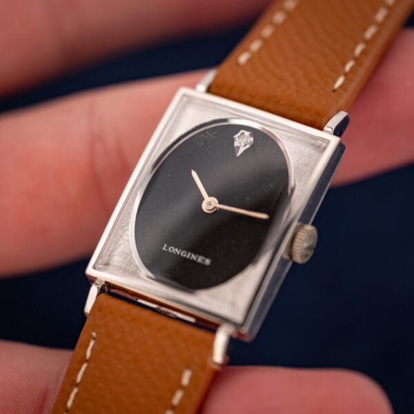 Longines-Wittnauer 3007-528 in hand angled, diamond marker and baton hands on black oval dial